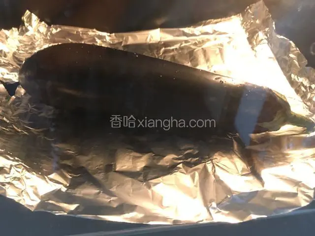 烤箱上下200度预热好。茄子放入垫有锡纸的烤盘，放入烤箱倒数第二层。直接先烤30分钟。若表皮烤得太皱，或觉得会烤焦，也可以将锡纸裹着茄子烤。