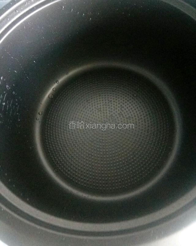 按下煮饭键将电饭锅加热后，放入少许豆油。