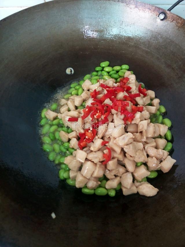 再把鸡丁、红椒倒进炒，加胡椒粉、鸡精炒匀
