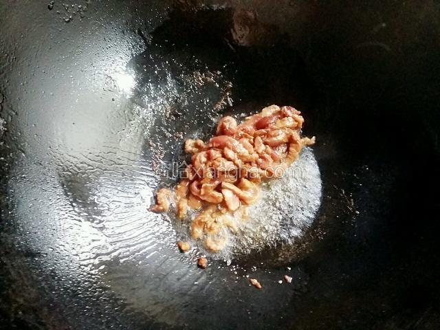 锅中加少许的色拉油，中火把肉丝炒散至九成熟