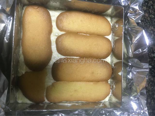 在拿手指饼干刷酒并铺一层