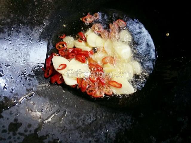 把蒜片和杭椒段倒入锅中，小火煸香