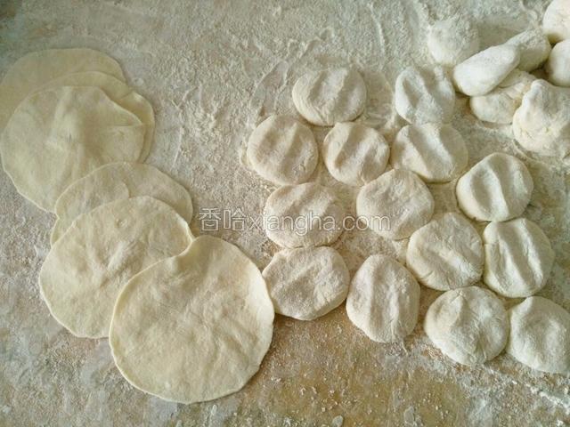 撒上薄面按扁，擀成饺子皮