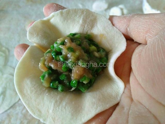 拿一个饺子皮，放入适量馅