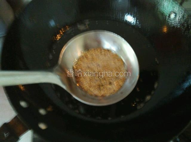 利用蒸羊腿的时间炸芝麻，在大铁勺放入适量白芝麻，锅内放食用油烧热至8层时关火，轻轻的将装有芝麻的铁勺盛点热油，然后马上将油过滤掉留下熟芝麻备用。