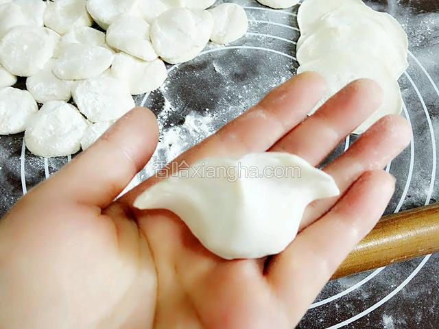 取一块饺子皮放手上添加适量的馅料捏出自己喜欢样式的饺子就可以啦！
