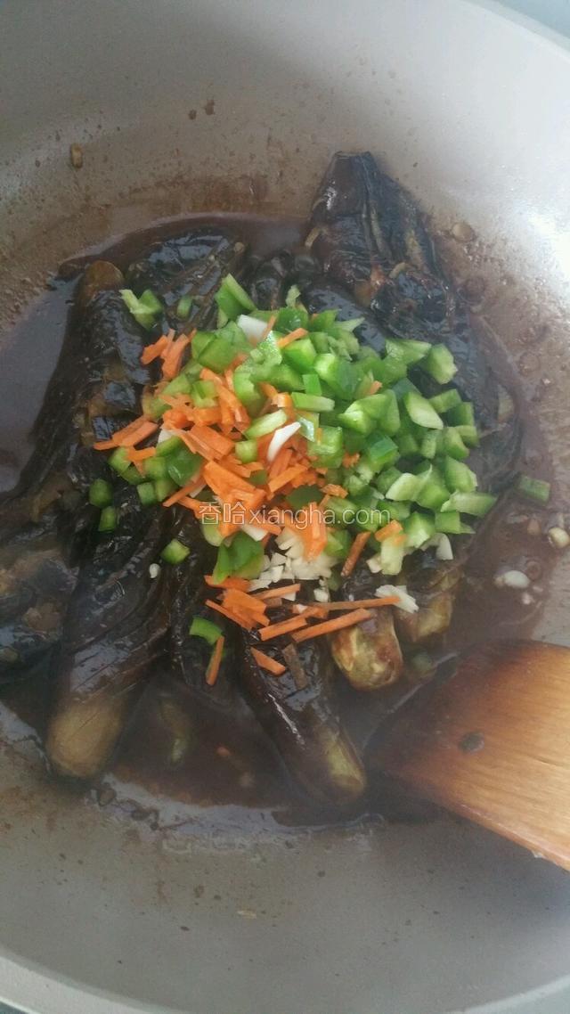 大火烧开转小火炖煮几分钟入味，加入切成小粒的青椒，胡萝卜和蒜末炒匀收汁即可出锅