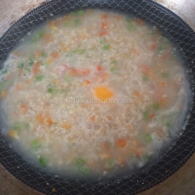 下麦片，搅拌，小火滚煮。其中一个鸡蛋直接下锅，另一个鸡蛋打散备用。