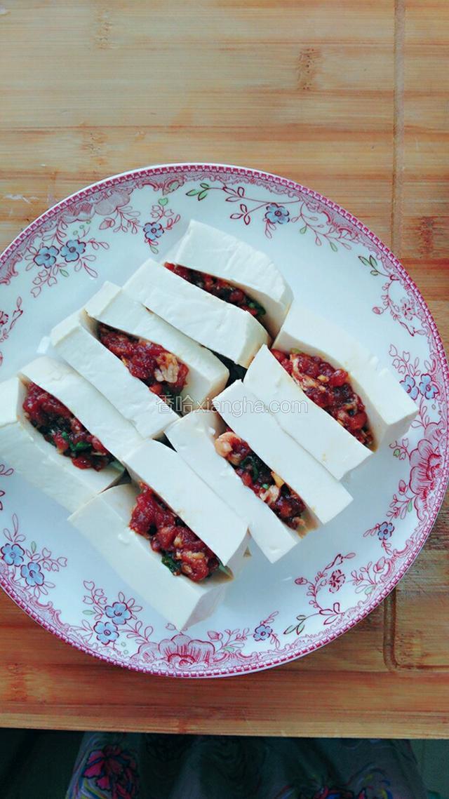 每两片豆腐中间塞上一层肉馅涂抹均匀备用