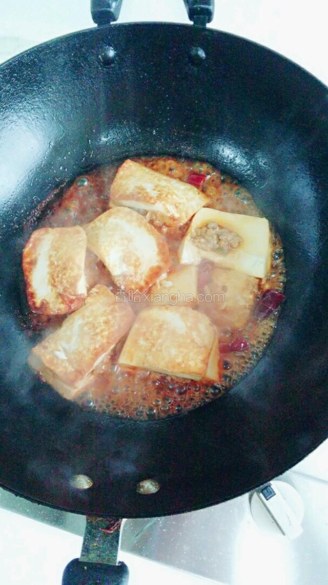 豆腐黄色翻面，豆腐全部煎好倒入料汁，炖三分钟，期间豆腐翻面，使其入味均匀