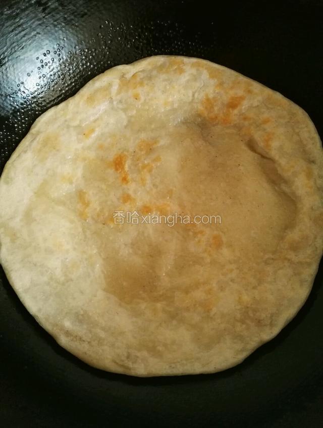 把大饼放入锅内小火至两面微黄盖上盖这时大饼内部鼓起大包说明里面已经熟了
