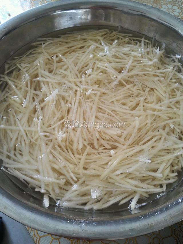 把土豆擦成丝。泡水待用。
