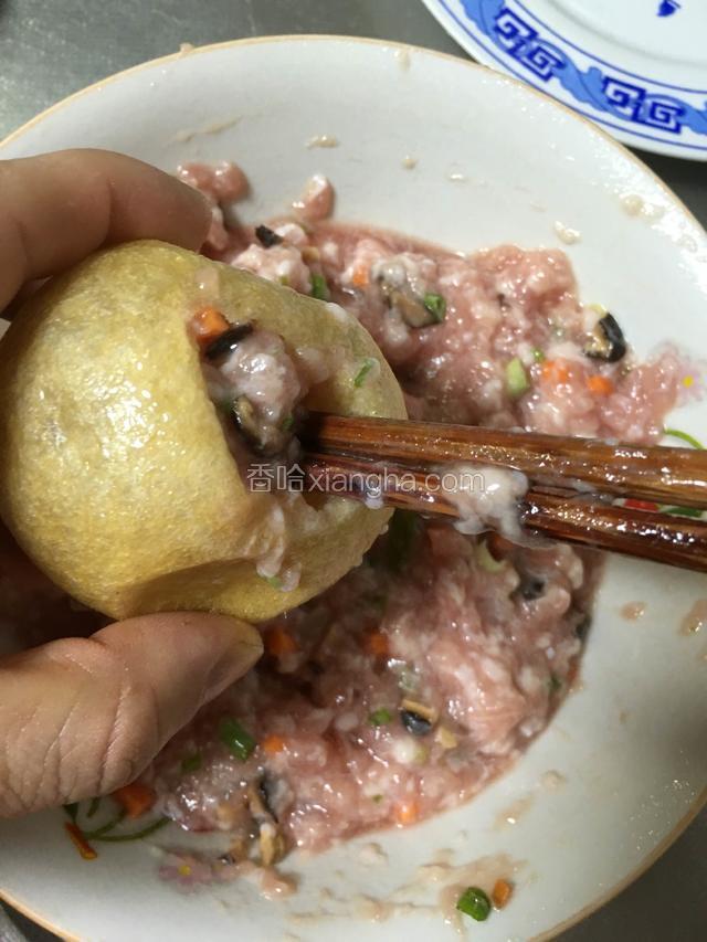 调和好的肉糜用筷子塞入油面筋内；