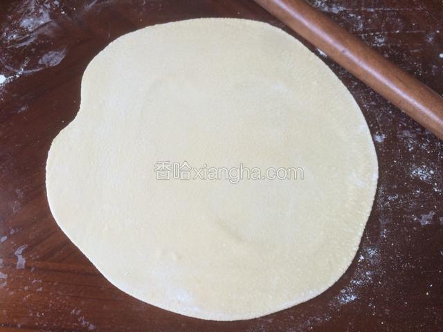 用擀面杖擀成近圆形，厚度约为2-3mm