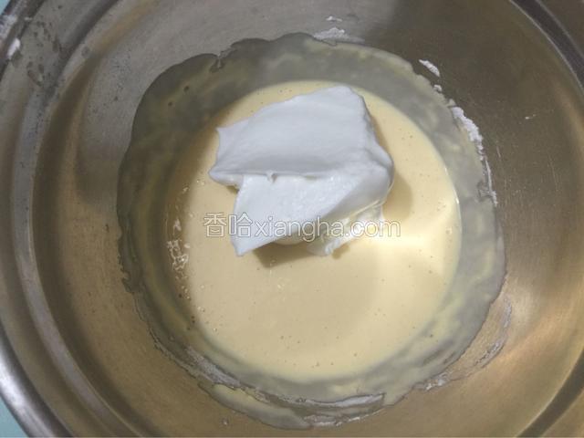 将蛋白霜三分之一放入蛋黄糊中拌匀
