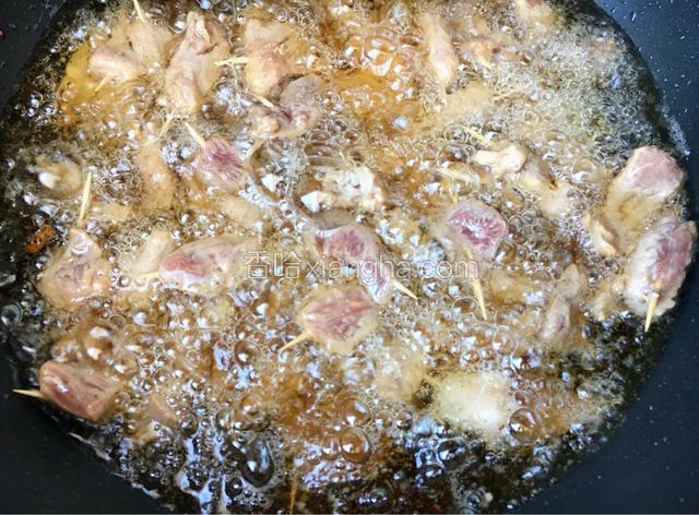 锅中加食用油烧热，把串好的肉放入锅中炸至表面微黄，此时锅中只需10g油，将多余的油倒出。