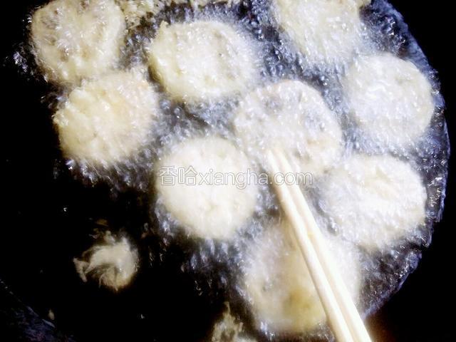 待藕夹炸制少硬时，用筷子把粘连在一起的藕夹分开继续炸制