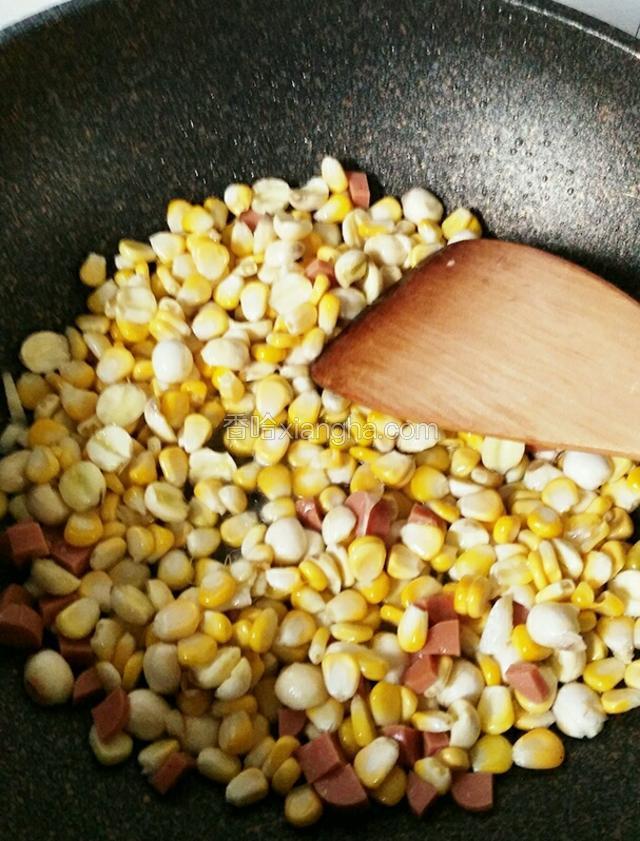 倒入玉米粒，莲子米和火腿丁翻炒一下并调入适量盐