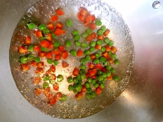 红萝卜、青豆下开水锅，放适量油、盐，焯水5分钟后剩出