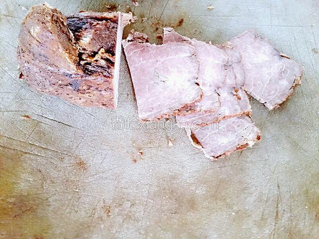 把牛肉在菜板上切均匀薄片