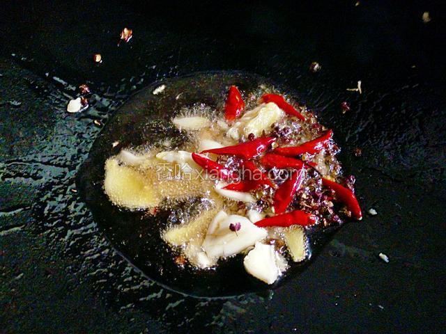 锅中倒适量油烧热，下姜蒜，花椒粒和干辣椒段小火翻炒出香味。