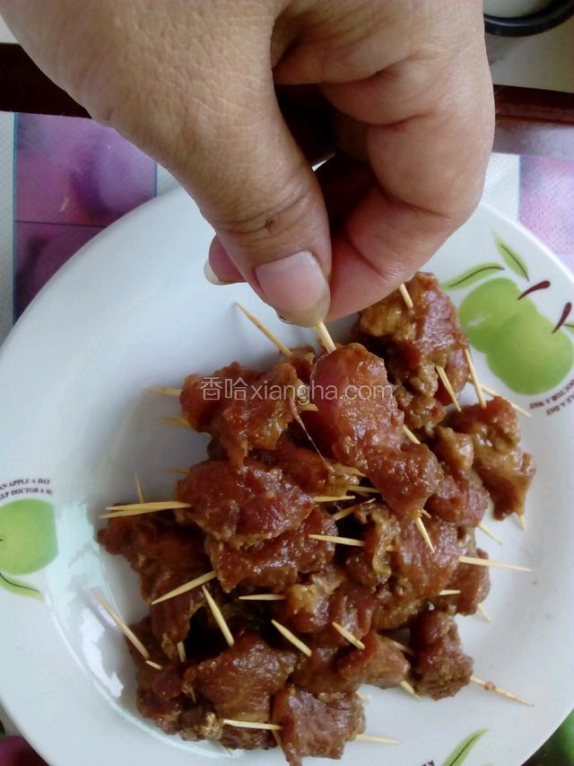 把腌制好的肉用牙签穿起来