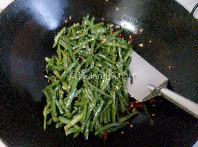 放入炸好的豇豆遍炒均匀