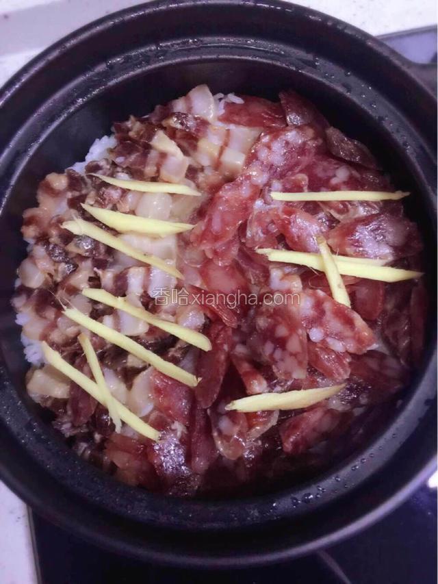 锅中水分快干时，米饭成蜂窝状，在米饭表面上铺上事先切好的腊肉和腊肠，还有姜丝，再盖上盖子小火焖十分钟后关火，不要打开盖子，继续盖着盖子焖15分钟，这样腊肠的味道更能渗入到米饭里。
