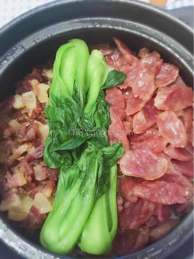 把焯好的油菜铺在已经蒸好的煲仔饭上