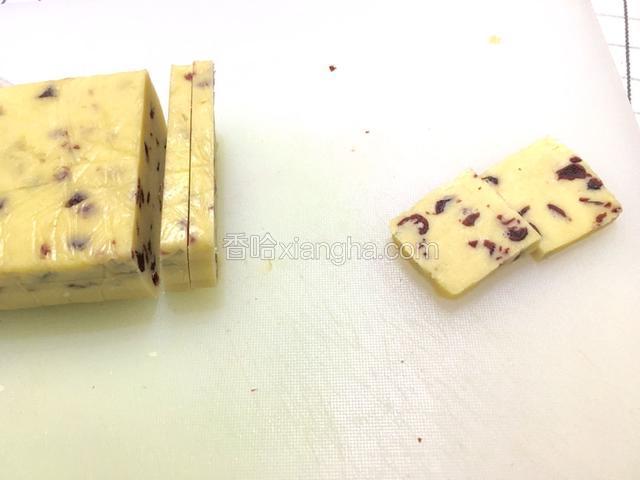 冻好后，拿出来，去掉保鲜膜。用刀切成0.7cm左右厚的片。要是饼干太大，可以从中间来一刀适当改小。