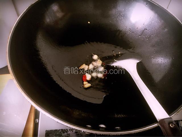 炒锅热油，依次放入生姜碎，干红椒及拍碎的大蒜子