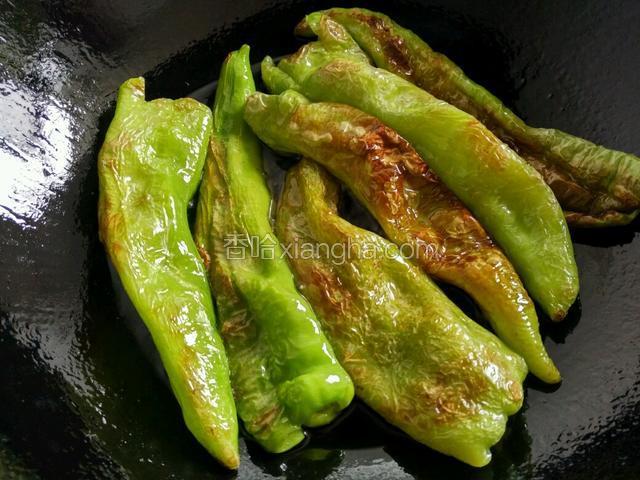 锅内放植物油待油热尖椒放入煎至虎皮状