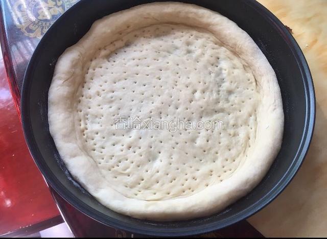 将面团擀皮铺在8寸披萨盘上，用叉子叉孔，留边缘厚点中间薄哦……