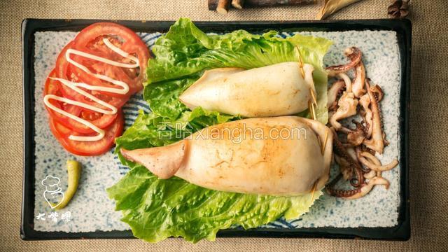 将煎过的鱿鱼包粉放入碟中，鱿鱼须炒好摆盘
