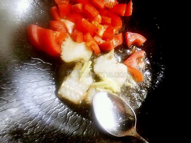 鱼骨煎好后，把姜丝和西红柿块下锅，中火炒一分钟