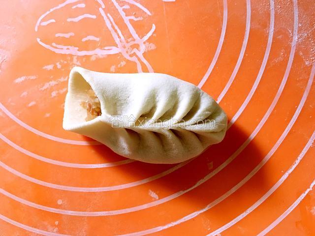 左手托着面片，右手食指和拇指配合左右交叉往上捏花