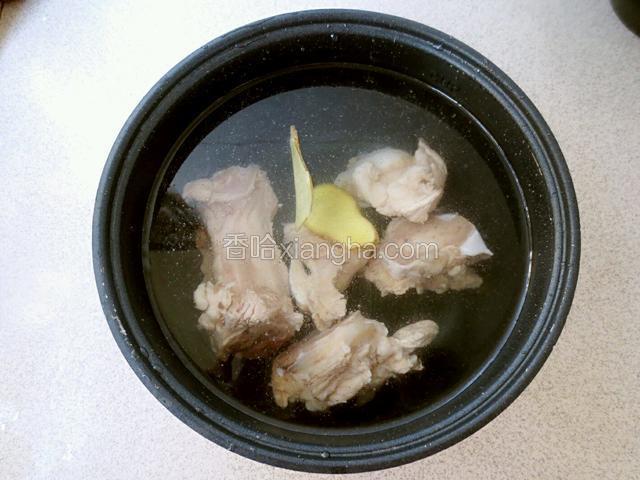 猪大骨放入电饭煲，放入姜片，加清水。