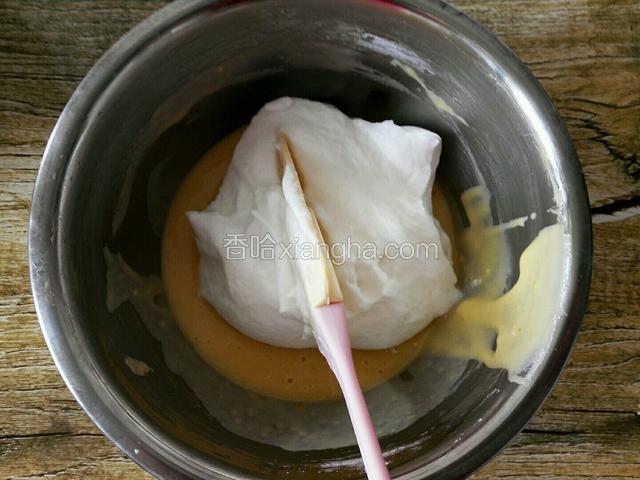 取一少部分蛋白加入蛋黄糊中，用刮刀翻拌均匀