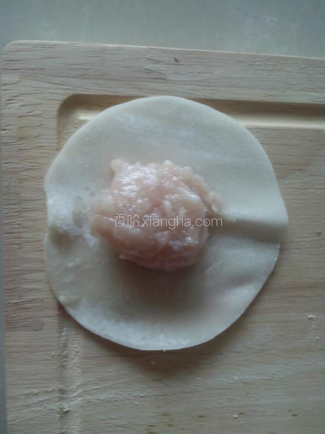 拿一张饺子皮，用小匙舀一匙鱼蓉放中间。