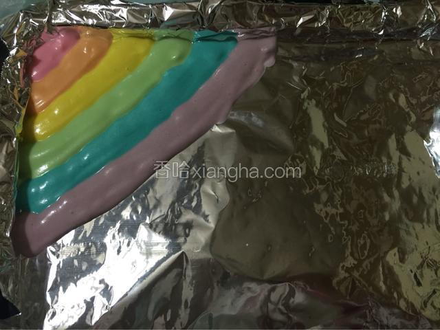 烤盘铺上锡纸，先取一个色彩蛋糕糊剪掉底部，慢慢挤上去，一个颜色挤好接着一个颜色挤上