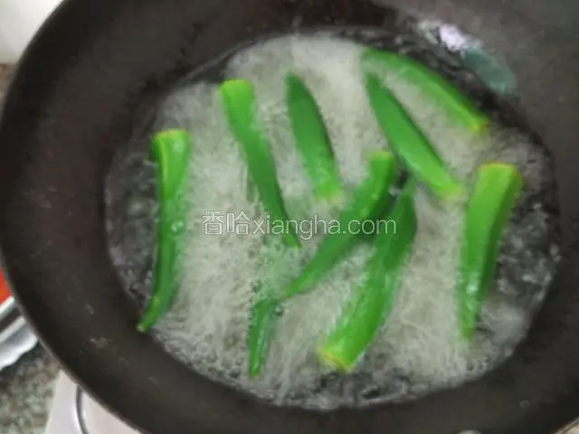 煮2分钟的秋葵会变得翠绿且软就熟了，盛起来（可以放到凉白开里面冷一冷再切）；