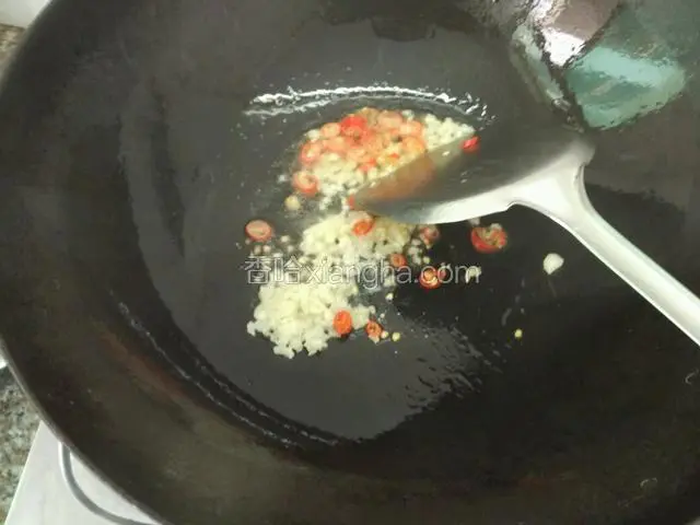 锅内倒入适量花生油（没有花生油可以用其他炒菜的油）七层热时放入蒜和辣椒翻一翻就会闻到香味；