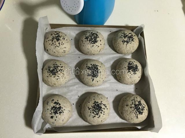 表面用喷壶喷上水撒上芝麻；