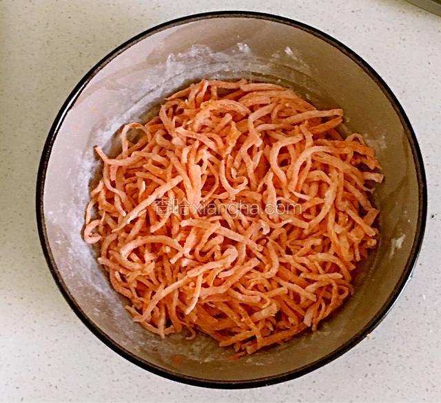 把面粉加入挤出水分的胡萝卜丝中拌均匀，让每个胡萝卜丝都蘸上面粉