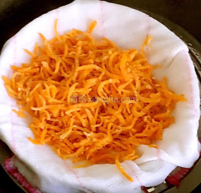 锅中加入适量的水把盘子放入锅中，盘中放入干屉布防止蒸的时候胡萝卜丝念一起成坨，放屉布也起这个作用