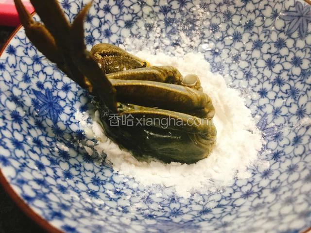 碗内倒入适量淀粉，将蟹剖开的那一面按在淀粉内