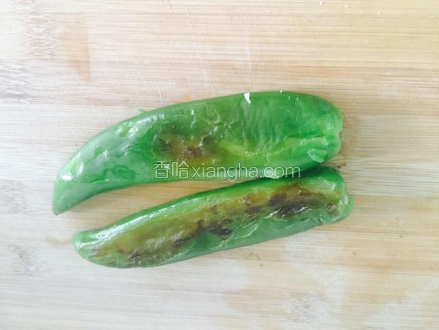 煎好的青椒放至不烫手剥去外皮
