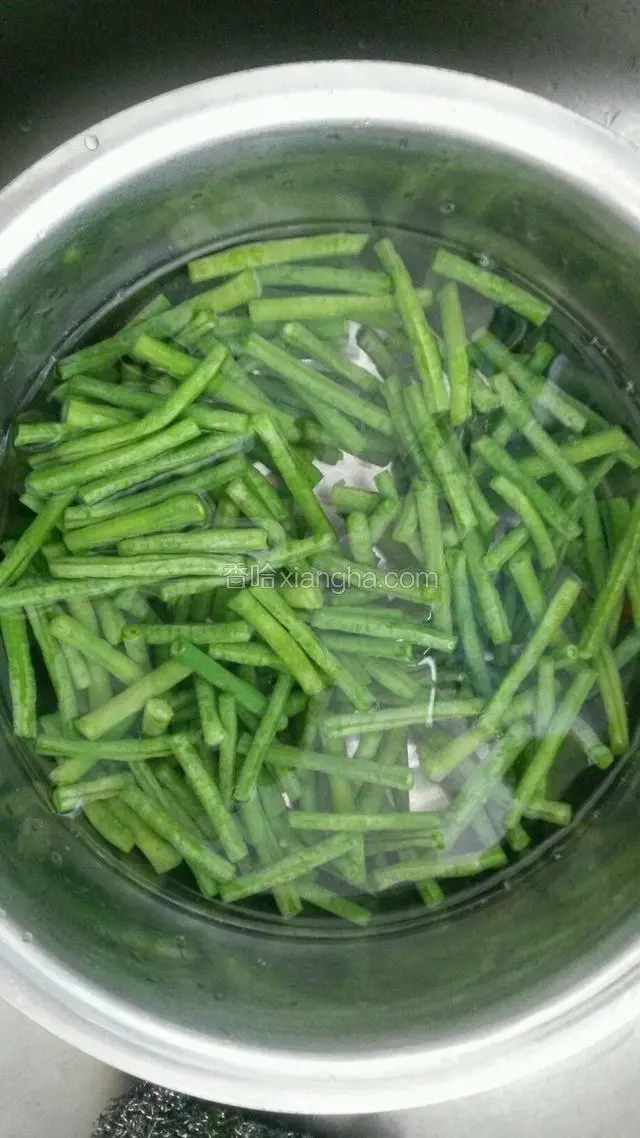 用开水把豇豆焯一下，水中放少许盐。
