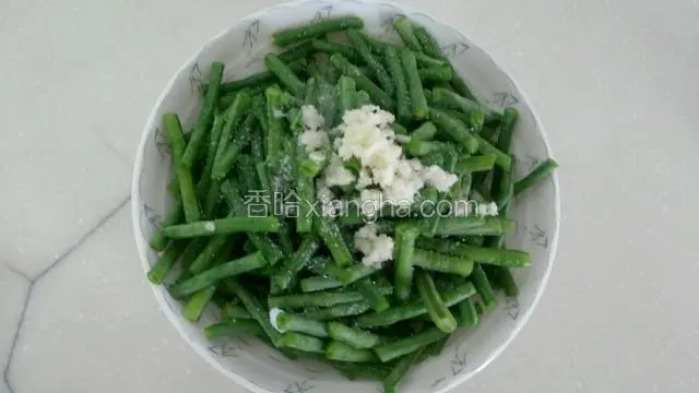 切适量蒜末放豇豆里，放适量盐、糖、香油。