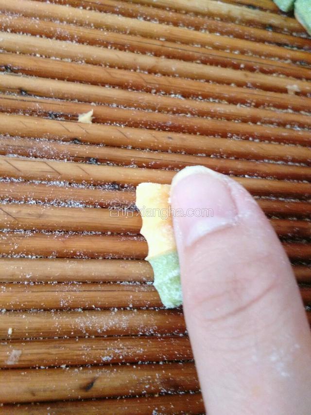 用大拇指从一边卷起。
